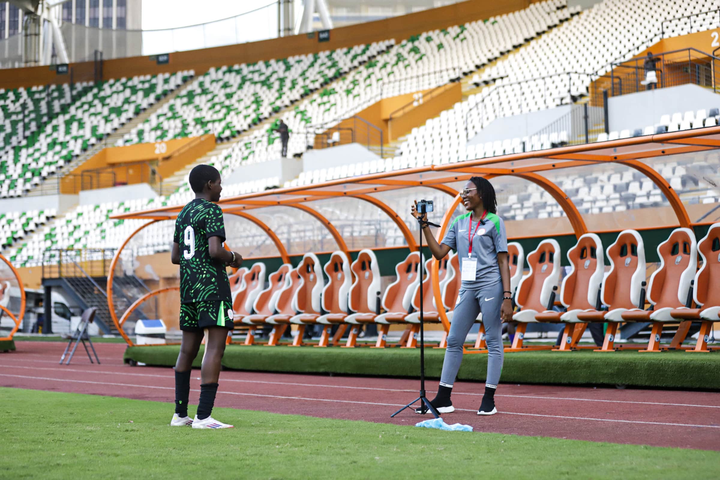 Dorcas Koki interviewing a young athlete pitch-side